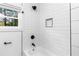 Modern bathroom with white subway tile, contrasting fixtures, and a shower niche at 578 Cedar Avenue, Atlanta, GA 30318