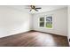 Bright, empty bedroom with dark vinyl floors, white walls, a ceiling fan and large window at 578 Cedar Avenue, Atlanta, GA 30318