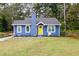 Charming blue home featuring a brick chimney, yellow door, and well-maintained landscaping at 578 Cedar Avenue, Atlanta, GA 30318