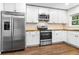Well-lit kitchen featuring stainless steel appliances, white cabinetry, and butcher block countertops at 578 Cedar Avenue, Atlanta, GA 30318