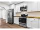 Well-lit kitchen features stainless steel appliances, white cabinets, and butcher block countertops at 578 Cedar Avenue, Atlanta, GA 30318