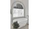 Bright bathroom features a soaking tub beneath an arched window at 1112 Kensington Ct, Johns Creek, GA 30022
