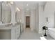 Bright bathroom with double vanity sinks, decorative mirrors, and soaking tub at 1112 Kensington Ct, Johns Creek, GA 30022