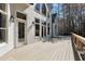 View of a large wooden deck of a modern home with wooded backdrop at 1112 Kensington Ct, Johns Creek, GA 30022