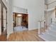 Grand foyer with staircase, hardwood floors, and view into the study at 1112 Kensington Ct, Johns Creek, GA 30022