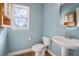 Powder room featuring pedestal sink, toilet, and built-in shelves for extra storage at 117 Olde Heritage Way, Woodstock, GA 30188