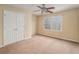 This is a spacious bedroom with a ceiling fan, tan carpet and a double door closet at 117 Olde Heritage Way, Woodstock, GA 30188