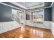 Formal dining room boasting elegant wainscoting, hardwood floors, a modern chandelier, and large windows overlooking the yard at 117 Olde Heritage Way, Woodstock, GA 30188