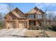 Charming brick home showcasing a three-car garage, complemented by manicured landscaping and a welcoming facade at 117 Olde Heritage Way, Woodstock, GA 30188