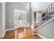 Bright foyer with hardwood floors, featuring a staircase with iron railings, a glass-paneled door and ample natural light at 117 Olde Heritage Way, Woodstock, GA 30188
