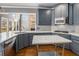 Bright kitchen features gray cabinets, stainless appliances, and a breakfast area with backyard views at 117 Olde Heritage Way, Woodstock, GA 30188