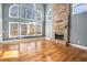 Sun-drenched living room featuring a stone fireplace, soaring ceilings, hardwood floors, and large windows with scenic views at 117 Olde Heritage Way, Woodstock, GA 30188