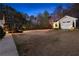 Expansive backyard at dusk featuring a shed, lush greenery, and a charming patio area at 340 Housman Dr, Fayetteville, GA 30215