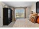 Well-lit bedroom showcasing a black armoire, patterned bedding, and bright natural light at 340 Housman Dr, Fayetteville, GA 30215