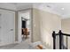 Hallway with white trim featuring a view into a bedroom with wood chair and neutral colors at 340 Housman Dr, Fayetteville, GA 30215