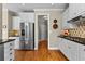 Well-lit kitchen featuring stainless steel appliances, white cabinets, and hardwood floors at 340 Housman Dr, Fayetteville, GA 30215