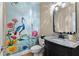 Bright powder room featuring whimsical floral wallpaper, a black vanity, and granite countertop at 340 Housman Dr, Fayetteville, GA 30215