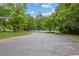 Exterior view of the community tennis court surrounded by lush trees and greenery, accessed from the parking area at 340 Housman Dr, Fayetteville, GA 30215