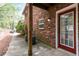 Brick home exterior with red door, small window, and concrete patio extending to the tree line at 3665 Chestnut Dr # A2, Atlanta, GA 30340
