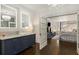 Bathroom with a navy vanity, framed mirrors, and view into main bedroom with fireplace at 591 E Morningside Ne Dr, Atlanta, GA 30324