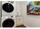 Well-lit laundry room offering stacked washer/dryer, wash basin, and a modern accent painting at 591 E Morningside Ne Dr, Atlanta, GA 30324