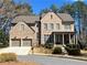 Charming two-story brick home featuring a two-car garage and well-manicured front lawn at 7920 Georgetown Cir, Suwanee, GA 30024