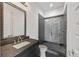 Modern bathroom featuring a granite countertop vanity and a sleek glass-enclosed shower with decorative tile accents at 223 16Th Nw St # 8, Atlanta, GA 30363