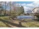 Expansive backyard featuring a covered pool, grassy lawn, and mature trees, perfect for outdoor enjoyment at 4833 Village North Ct, Atlanta, GA 30338