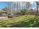 Spacious backyard featuring a covered pool, lush lawn, mature trees, and a storage shed at 4833 Village North Ct, Atlanta, GA 30338