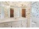 Bathroom with a corner sink, mirrored vanity, patterned wallpaper, and white wainscoting at 4833 Village North Ct, Atlanta, GA 30338