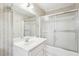 Cozy bathroom featuring a single sink vanity, frosted shower door, and decorative patterned wallpaper at 4833 Village North Ct, Atlanta, GA 30338
