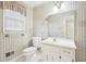 Bright bathroom featuring a pedestal sink, toilet, hexagon tile floor, and classic patterned wallpaper at 4833 Village North Ct, Atlanta, GA 30338