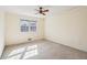 Bright bedroom features a ceiling fan, neutral walls and carpet, and a double window at 4833 Village North Ct, Atlanta, GA 30338