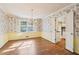 Floral wallpapered dining room with hardwood floors, chandelier, and adjacent kitchen at 4833 Village North Ct, Atlanta, GA 30338