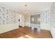 Dining room with floral wallpaper, hardwood floors, chandelier, and view of the living room at 4833 Village North Ct, Atlanta, GA 30338