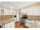 Bright kitchen features white cabinetry, granite countertops, stainless appliances, and hardwood flooring at 4833 Village North Ct, Atlanta, GA 30338