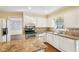 Bright eat-in kitchen with white cabinets, granite counters, stainless appliances, and hardwood floors at 4833 Village North Ct, Atlanta, GA 30338