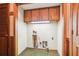 Unfinished laundry room with upper cabinets, damaged walls and outdated linoleum flooring at 4833 Village North Ct, Atlanta, GA 30338