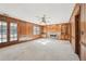 Spacious carpeted living room featuring a stone fireplace and wood paneling at 4833 Village North Ct, Atlanta, GA 30338