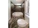 Bathroom featuring stone tile walls and flooring, skylight and a built-in bathtub with shower at 105 Creekwood Ln, Fayetteville, GA 30214
