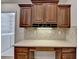 Kitchen desk area with wood cabinets, granite counters, and overhead lighting at 1535 Duluth Hwy # 1001, Lawrenceville, GA 30043