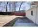 Backyard featuring a red fence, mature trees, and access door at 2811 Birchwood Sw Ct, Marietta, GA 30060
