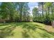 Spacious backyard with mature trees and a fence, offering a blend of sun and shade at 3040 Wax Wing Nw Ct, Kennesaw, GA 30144