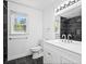 Modern bathroom with a toilet, black tiled floors and a white double sink vanity at 3040 Wax Wing Nw Ct, Kennesaw, GA 30144
