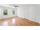 A bright bedroom with hardwood floors, two windows offering natural light, and a ceiling fan at 3040 Wax Wing Nw Ct, Kennesaw, GA 30144
