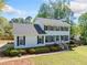 Charming two-story home featuring a classic white facade, black shutters, and lush landscaping at 3040 Wax Wing Nw Ct, Kennesaw, GA 30144