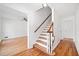 Inviting foyer featuring hardwood floors, staircase with wood railing, and an adjacent, bright living space at 3040 Wax Wing Nw Ct, Kennesaw, GA 30144