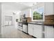 Bright kitchen with white cabinets, modern appliances, tile backsplash, and adjacent laundry area at 3040 Wax Wing Nw Ct, Kennesaw, GA 30144