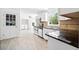 Open concept kitchen featuring white cabinets, stainless appliances, tile floors and adjacent laundry area at 3040 Wax Wing Nw Ct, Kennesaw, GA 30144