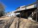 A backyard featuring a covered patio area connected to a row of townhomes with privacy fences at 358 Azalea Cir, Cumming, GA 30040